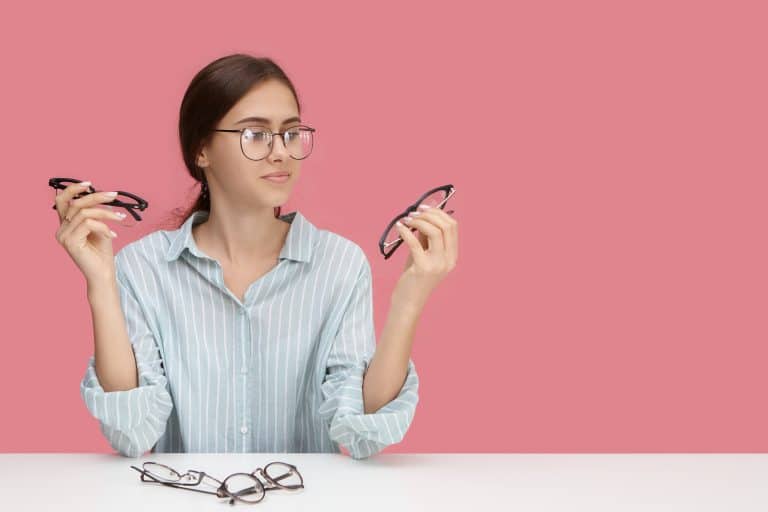 Femme hésitant entre deux montures de lunettes